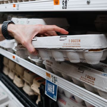 man grabs carton of eggs at supermarket